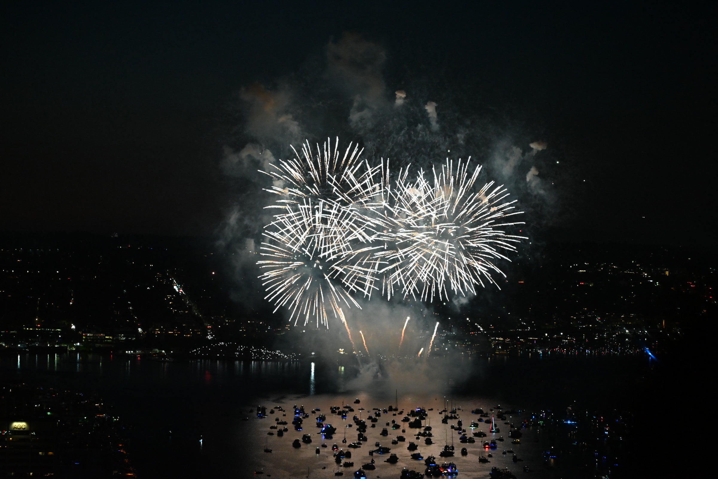 White Independence Day fireworks reflected across Lake Union
